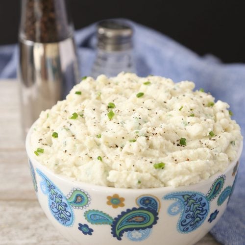 Mashed potatoes in a bowl with salt and pepper in the background.