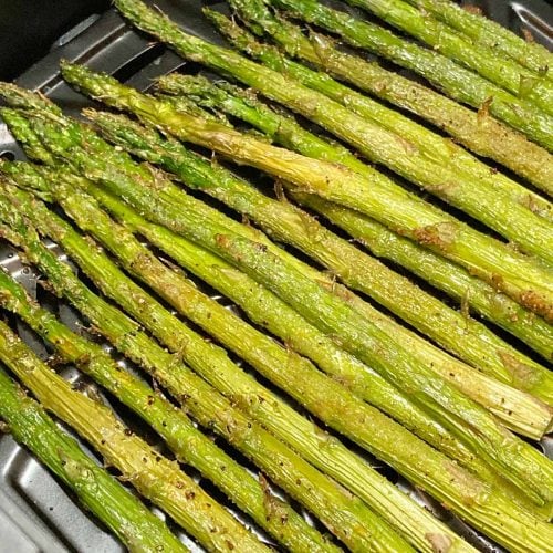 A bunch of seasoned asparagus cooked in air fryer.
