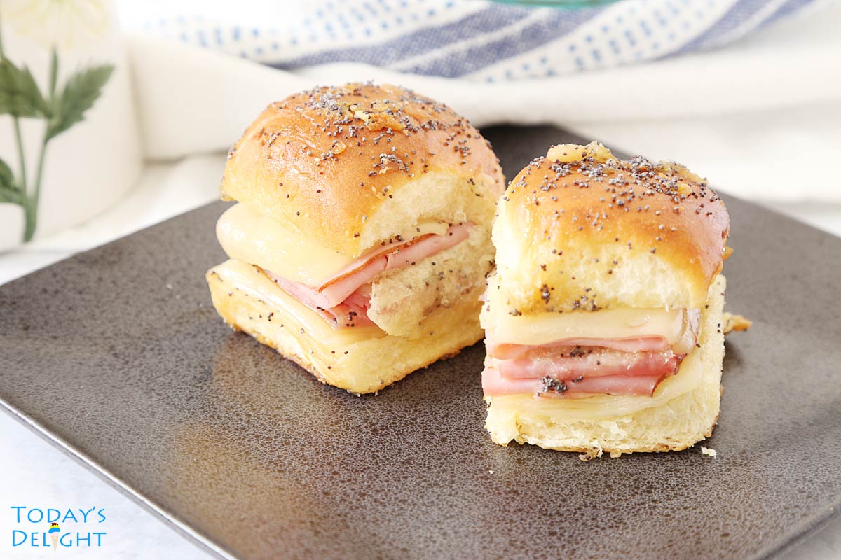 Two ham cheese sliders on a plate.