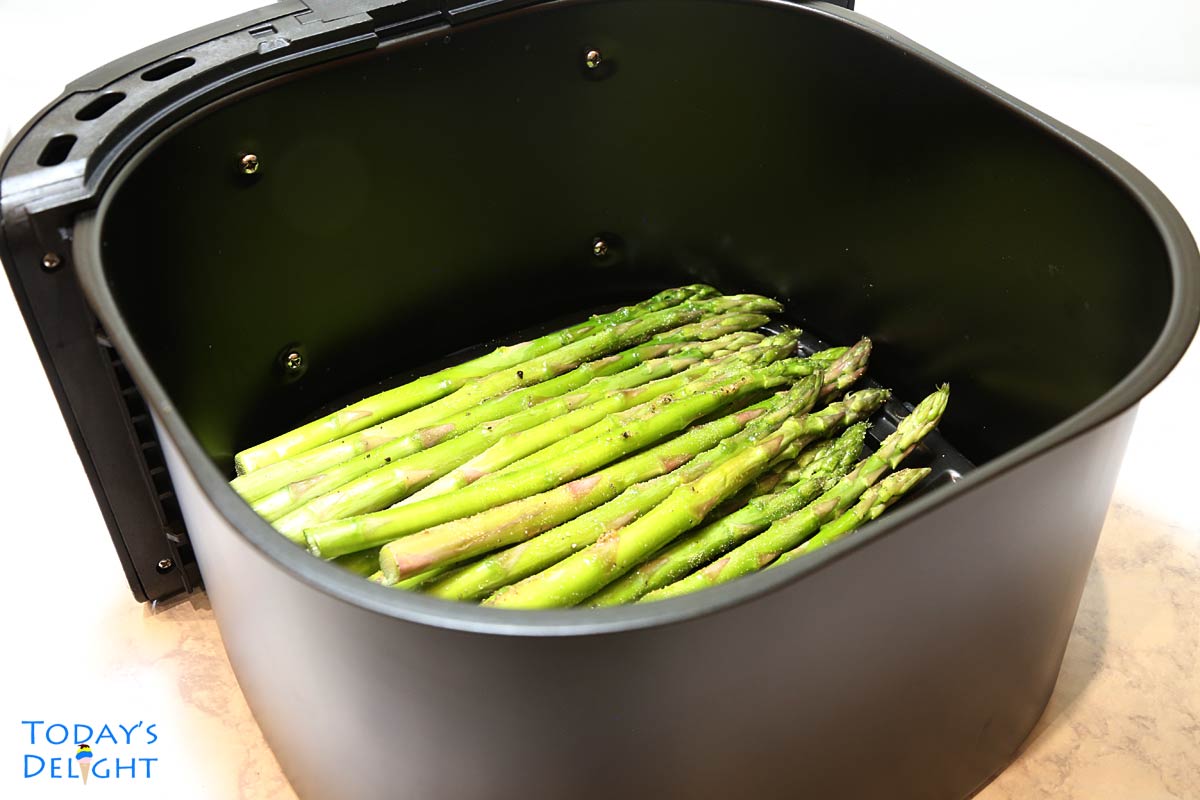 A bunch of asparagus in air fryer basket