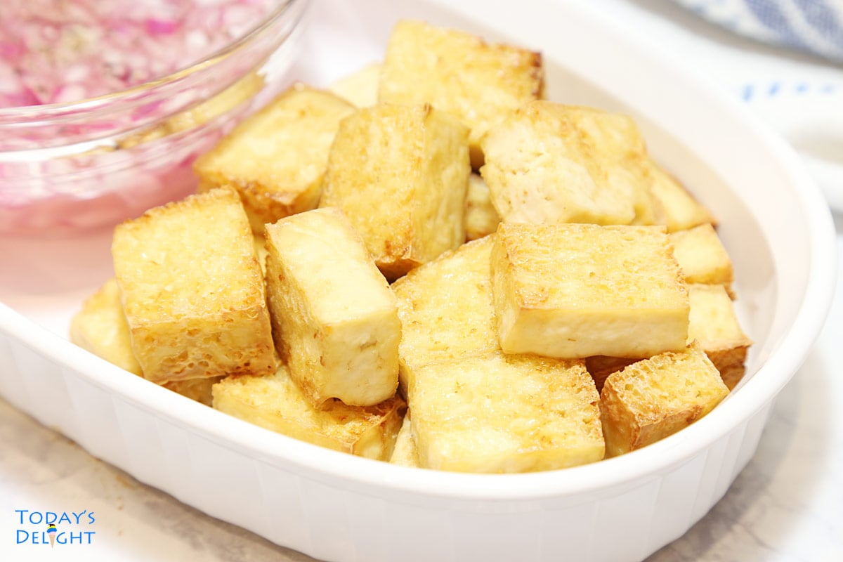 Sliced air fryer tofu with a side of vinegar and onion dip.