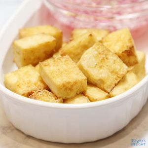 Sliced air fried tofu with vinegar and onion dip on the side.
