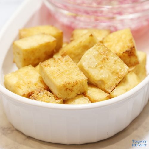 Sliced air fried tofu with vinegar and onion dip on the side.