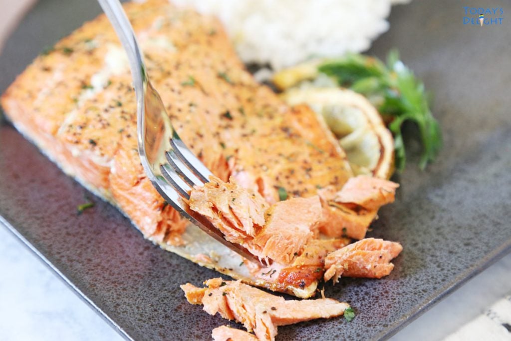 Lemon pepper salmon flaked with a fork and a side of white rice.