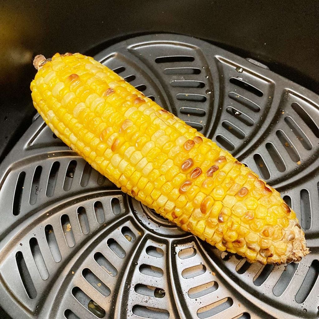 One air fryer corn on the cob in basket.