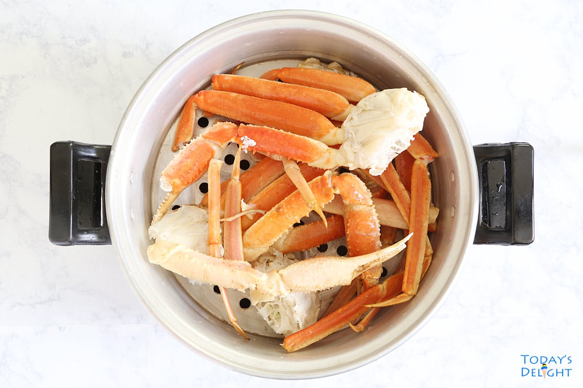 Snow crab legs in steamer basket.