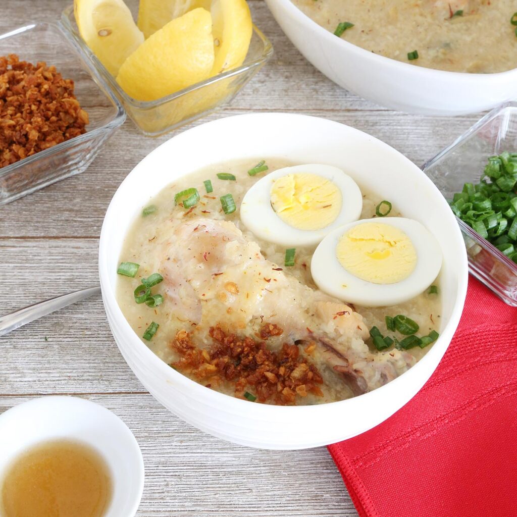 Arroz Caldo is a porridge with chicken, hard-boiled egg sprinkled with toasted garlic and green onion seasoned with lemon and fish sauce.